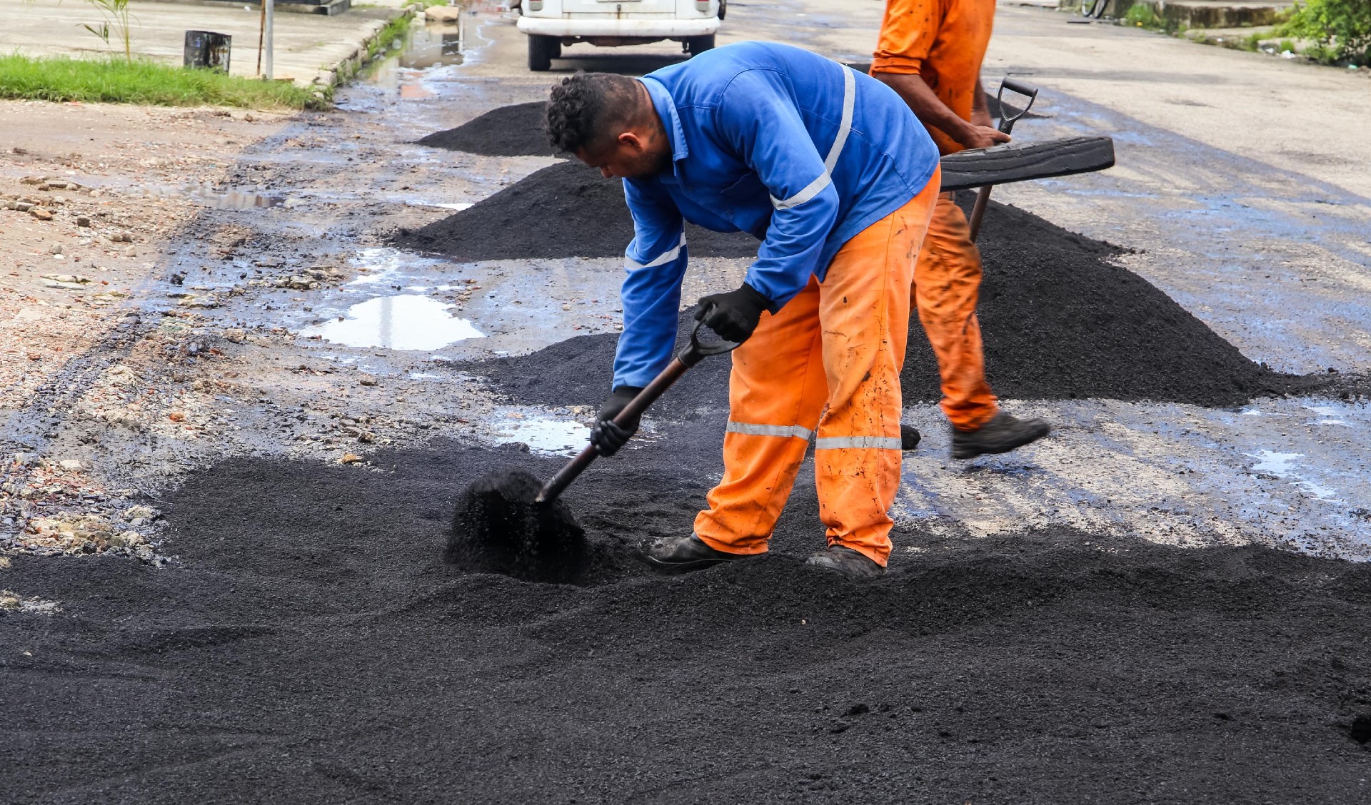 homens tapando buracos numa avenida